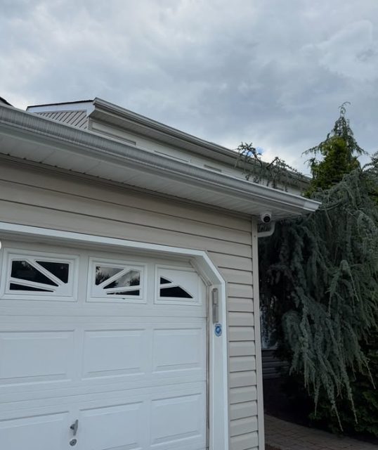 Security camera installed beneath the eave beside a garage door