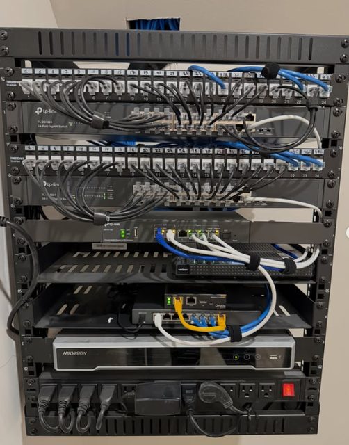 Network equipment rack with patch panels, switches and connected cabling