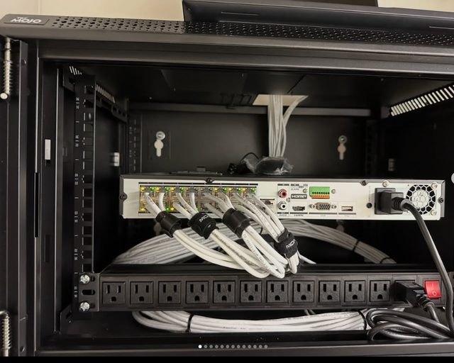 Network cables and power connections at the back of an equipment cabinet